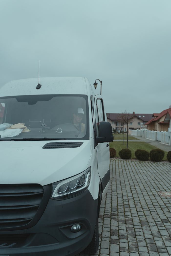 The Art of Drawing Readers In: Your attractive post title goes here White delivery van parked in a suburban area with driver inside on a cloudy day.